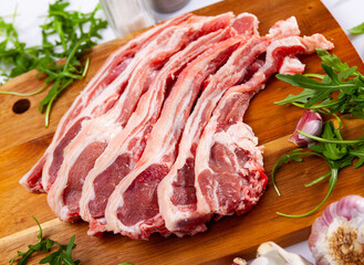 Chops of fresh raw lamb ribs with garlic and greenery. Ingredients for cooking
