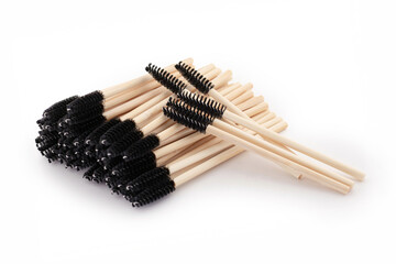 Black and wooden eyelash brushes on white background, beauty accessories, eyelash extensions, eyelash lamination