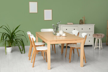 Interior of modern dining room with teapot and cups on table