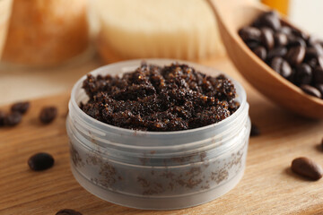 Jar with coffee body scrub on wooden background, closeup