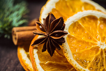 Dried oranges with spices on the rustic wooden background. Christmas mood. Selective focus. Shallow depth of field.