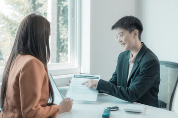 The person in question consults the car salesman with the purchase agreement for inspection at the showroom. The customer receives a vehicle purchase contract before signing with the dealer.