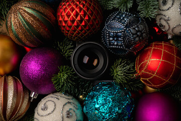 Hidden camera lens looking through Shiny colorful christmas balls with fir branches. Photography background. Christmas background.