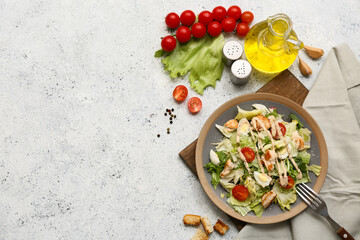 Plate with tasty chicken Caesar salad and ingredients on white background