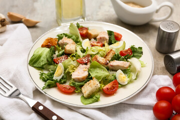Plate with tasty chicken Caesar salad on grey background, closeup