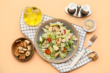 Plate with tasty chicken Caesar salad and bowl of croutons on orange background
