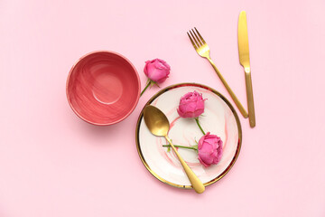 Stylish table setting with beautiful rose flowers on pink background