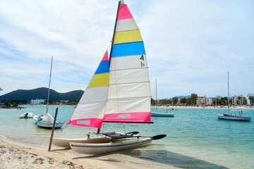Naklejka premium Sailing on a tranquil summer sea with colorful sailboats in a beautiful coastal setting