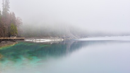 Misty reflections over Jiusaigou Scenic Area showcasing tranquil waters and lush greenery in Sichuan