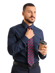 Young businessman in suit with coffee cup straightening his tie on white background