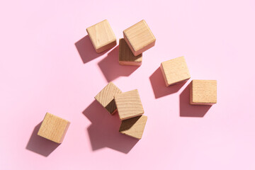 Wooden building cubes on pink background