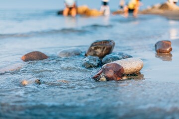 Beautiful summer view of rocks and water at Pigeonhole Scenic Area in Beidaihe with visitors enjoying the beach