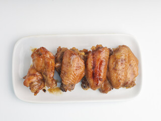 Grilled chicken wings on white rectangular plate