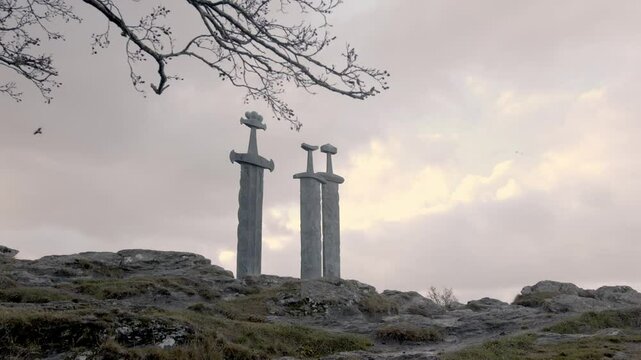 Wide shot of the monument called Sverd i fjell in Stavanger Norway with a branch of a tree in the foreground.