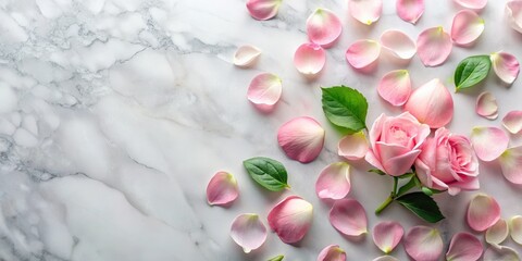 Obraz premium Soft pink rose petals scattered on a white marble surface, with a few fresh green leaves in the corner