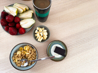 Healthy breakfast spread with fruits, cereal, and coffee on a wooden table