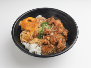 Rice served with chicken teriyaki sauce and sunny side up egg in black bowl