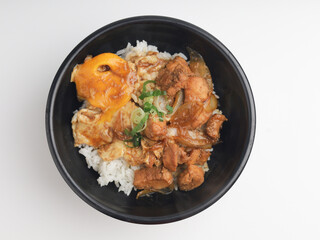Rice served with chicken teriyaki sauce and sunny side up egg in black bowl
