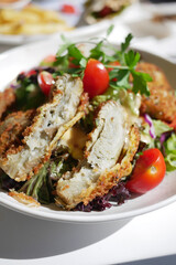Enjoy a plate of Delicious Fried Chicken Cutlets served with Fresh Salad