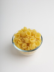 Conchiglie pasta in a bowl on white background