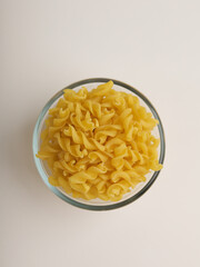 Fusilli pasta in a bowl on white background
