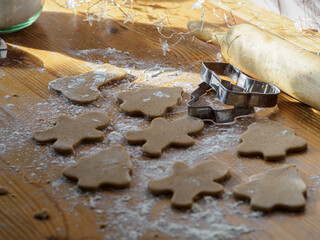 Christmas cookie dough and molds on floured work table