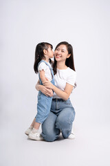 Full body image of Asian mother and daughter posing on white background © STOCK88PHOTOGRAPHER