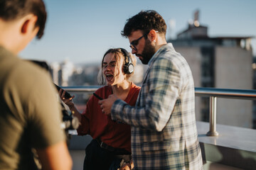 Multiracial business colleagues collaborate creatively while working on a high-rise balcony at sunset. The vibrant setting inspires dynamic interaction.