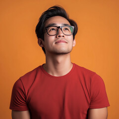 Fototapeta premium Inspirational young man looking upwards studio setting portrait photography warm environment close-up perspective positive mindset