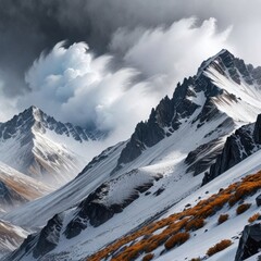 Majestic snow-capped mountain peaks with autumn vegetation on the slopes under dramatic skies