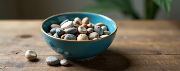 Blue bowl filled with a few small pebbles on a wooden table, natural, minimalist, centerpiece