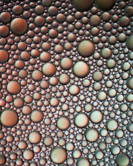 Abstract pattern of metallic bubbles on reflective surface