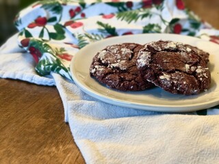 Chocolate red velvet crinkle Christmas cookies served on a plate with a festive holiday themed...