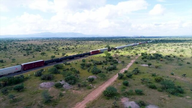 Vista a&eacute;rea de ferrocarril sobre campos verdes en un dia soleado 