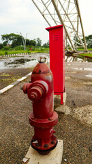 Close-up of a red fire hydrant and red utility box in an outdoor setting, with a background of...
