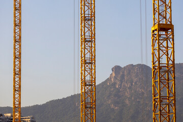 December 17, 2024,Hong Kong.Construction cranes in Hong Kong with the famous Lion Rock in the background.