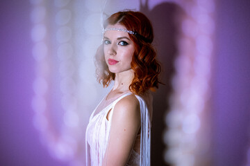 A young woman with red hair, dressed in stylish white clothing reminiscent of 1920s fashion. Her...