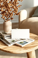 Obraz premium Blank card mockup on wooden table, magazines, beige couch, sunlight, home interior design, branding.