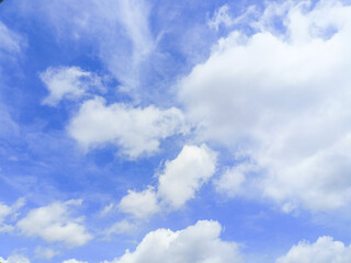 Obraz premium The bright blue sky is decorated with white clouds floating around, creating a beautiful and calming sky view.