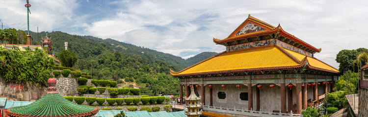 Fototapeta premium Panoramic view Kek Lok Si Temple Penang Malaysia. traditional Chinese architecture golden roofs pagoda lush greenery modern city skyline famous tourist attraction cultural heritage serene landscape