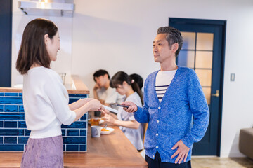 飲食店で電子マネー決済をする男性