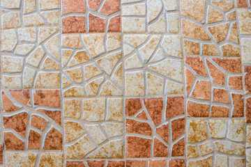 2023-12-31 A MULTI COLORED MOSIAC DESIGN WITH SUBDUDED ORANGE AND GRAY SQUARES 