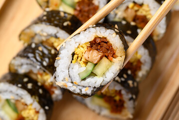 Gimbap or kimbap, Korean food made from cooked rice with vegetables, meat, egg and wrapped with...