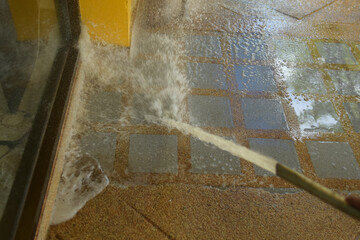 pressure washer spraying water on a tiled floor, concrete floor cleaning with pressure washer