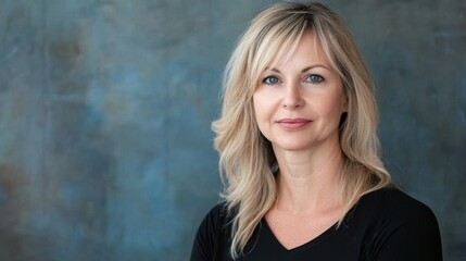 Fototapeta premium Portrait of a woman with blonde hair against a muted blue distressed paper background highlighting natural beauty