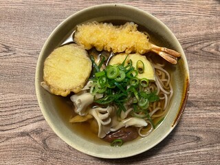 木目のテーブルの上の天ぷらそば