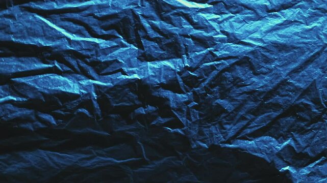 Blur creased foil. Scratched texture. Defocused blue black color shiny glow distressed old film swaying motion dark grunge abstract background.