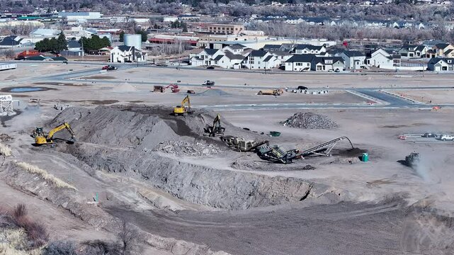 Aerial heavy equipment operation Payson Utah. Central Utah city. New home construction, heavy industrial earth moving equipment. Urban and rural landscape in mountain valley. 