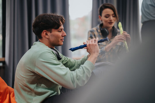Two students engage in a music lesson, playing recorders in a relaxed classroom setting. The educational environment fosters creativity and learning through musical practice.