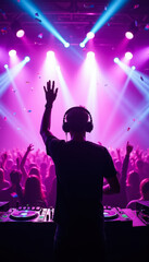 A silhouette of a DJ raising one hand while playing music on stage with a vibrant purple and pink light show and a crowd in the background